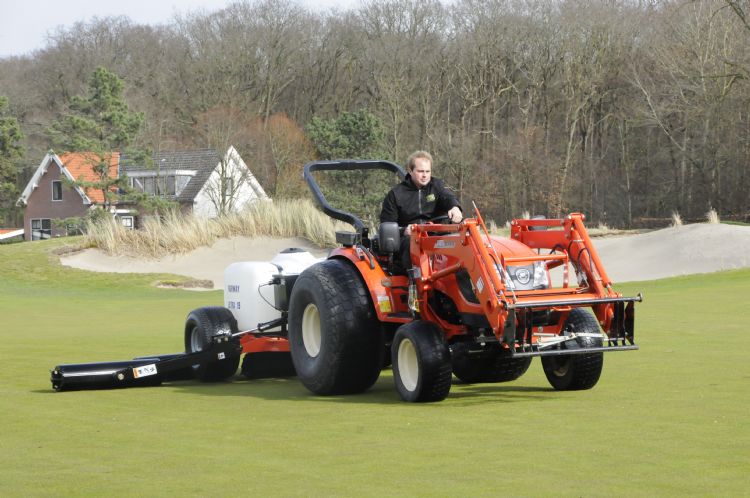 Willem Slats junior demonstreert de fairwayroller op Groendael.